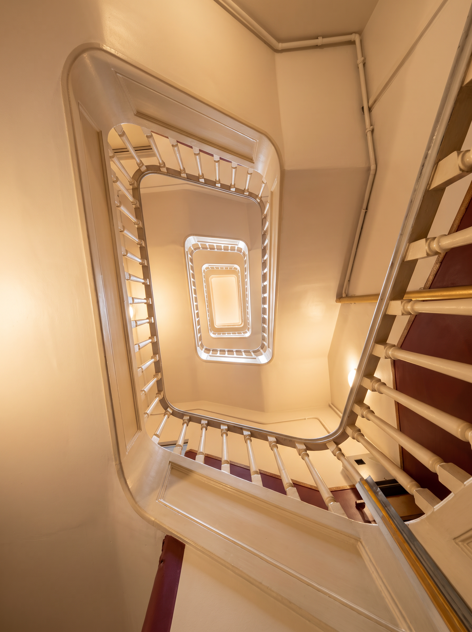 Classic stairwell spiralling up towards the skylight